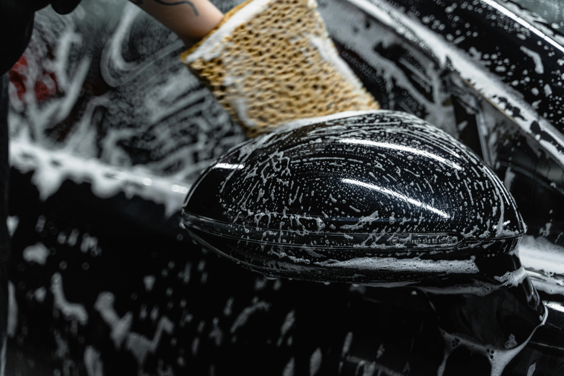 a person washing a car with a sponge